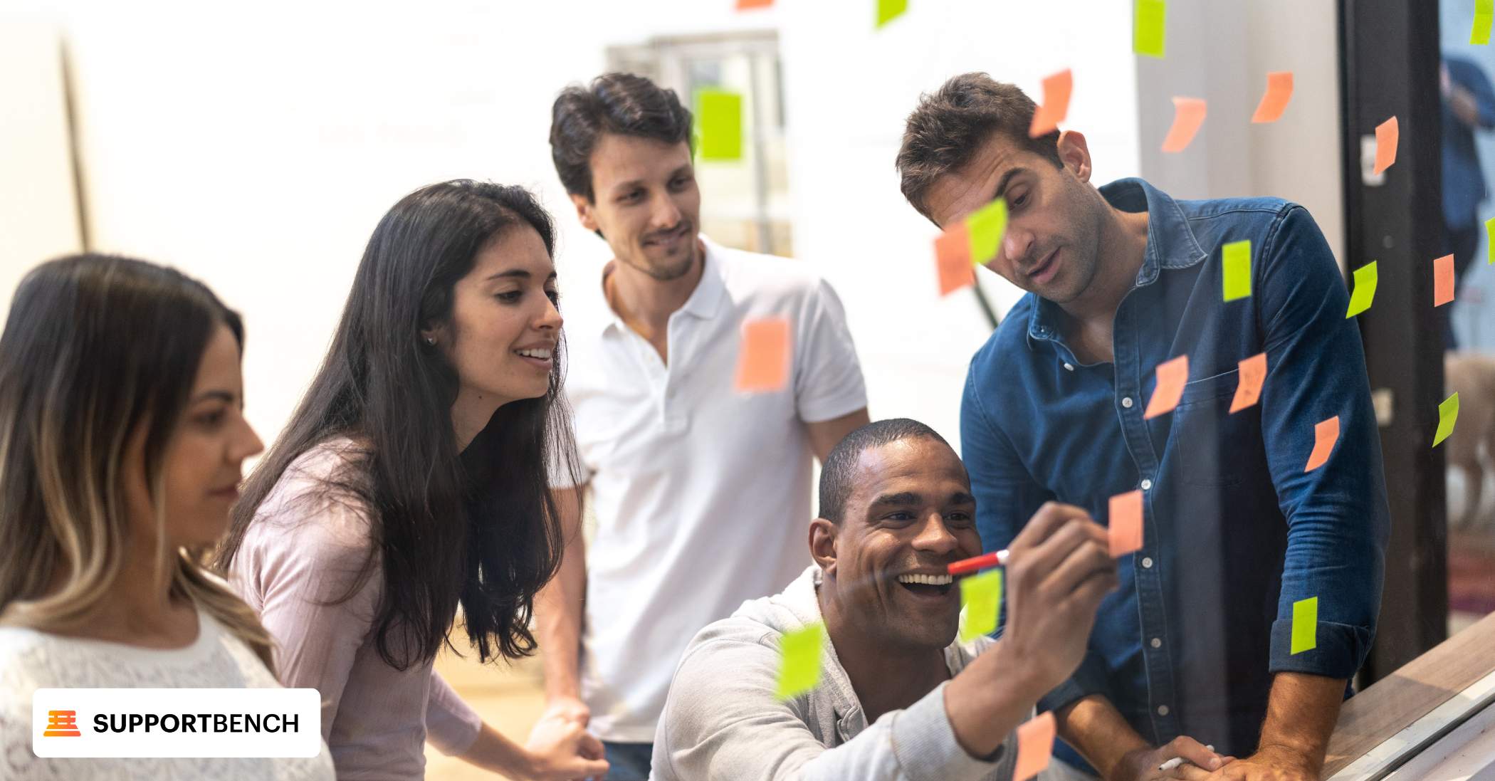 A team stands by a whiteboard adorned with sticky notes, strategizing to optimize customer self-service solutions.